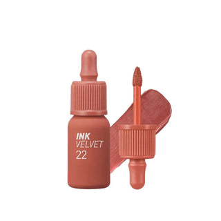 peripera's Ink The Velvet Lip Tint in color 22 Bouquet Nude, displayed with its doe-foot applicator, which resembles a dropper but is not functional as one. It also includes a swatch of the color.