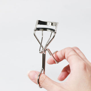 shu uemura's Iconic Eyelash Curler with a mushroom shape, designed for precise curling.