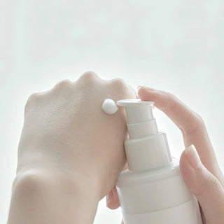 Close-up of the pump dispenser on Anua's Heartleaf 70% Daily Lotion with a small amount dispensed, showing its creamy texture.