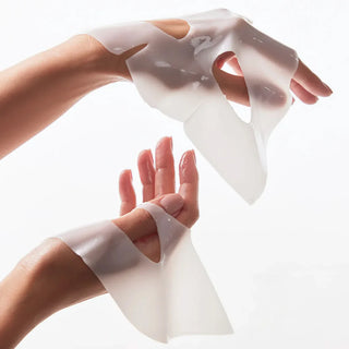 A model’s hand holding two Bio-Collagen Real Deep Masks, demonstrating their hydrating properties.