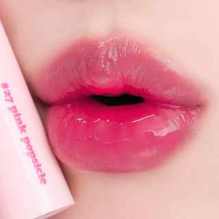 Close-up of rom&nd's Juicy Lasting Tint in color 27 Pink Popsicle applied to the model's lips.