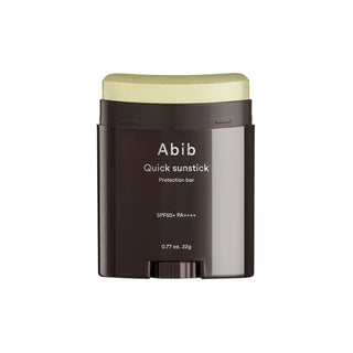 Abib's Quick Sunstick Protection Bar SPF 50+ PA++++ with the cap off. The stick has a yellow sheen but appears colorless when applied, providing a clear finish.