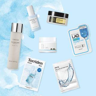 Dew Me, I'm Thirsty! Set curated by Vanessa and Jeanha. This kit includes Tirtir Milk Skin Toner, Skin1004 Madagascar Centella Hyalu-Cica Blue Serum, Torriden Dive-In Low Molecule Hyaluronic Acid Sheet Mask, Abib Mild Acidic pH Sheet Mask Aqua Fit, TONYMOLY Master Lab Mask Sheet #Hyaluronic Acid, ROUND LAB 1025 Dokdo Cream, and COSRX Advanced Snail Hydrogel Eye Patches.