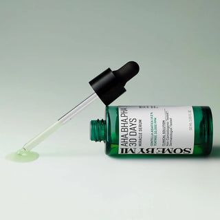 SOMEBYMI's AHA BHA PHA 30 Days Miracle Serum with the dropper dispensing a translucent, light green serum.
